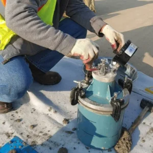 Concrete technician operating field testing equipment to evaluate fresh concrete on a commercial construction project.