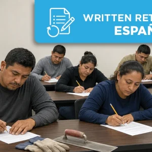 Latino concrete construction professionals taking a Spanish written retest in a classroom with hard hats and flatwork tools nearby.